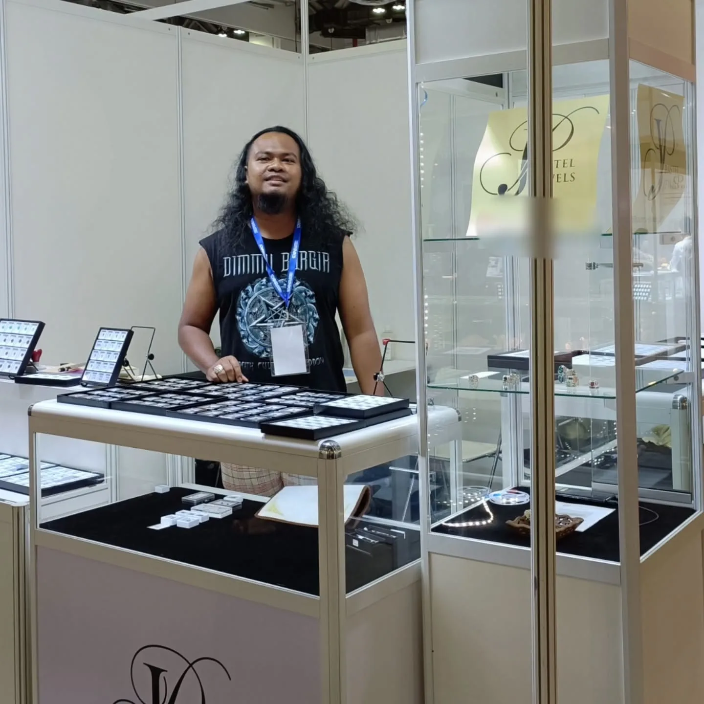The founder of Pastel Jewels at the shop's booth, with trays of stones and a glass display tower
